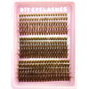Un plateau rose contenant diverses extensions de faux cils naturels et fins, dans différentes nuances de brun et d'or.