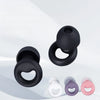 A collection of silicone earplugs in black, white, and pink are shown against a light background.