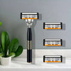 A black and silver classic multi-blade safety razor with three interchangeable blades displayed on a white marble surface.