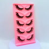 Plateau en plastique rose contenant cinq paires de faux cils dramatiques.