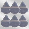 Un ensemble de six éponges de maquillage triangulaires en tissu gris doux avec des bandes rose pâle.