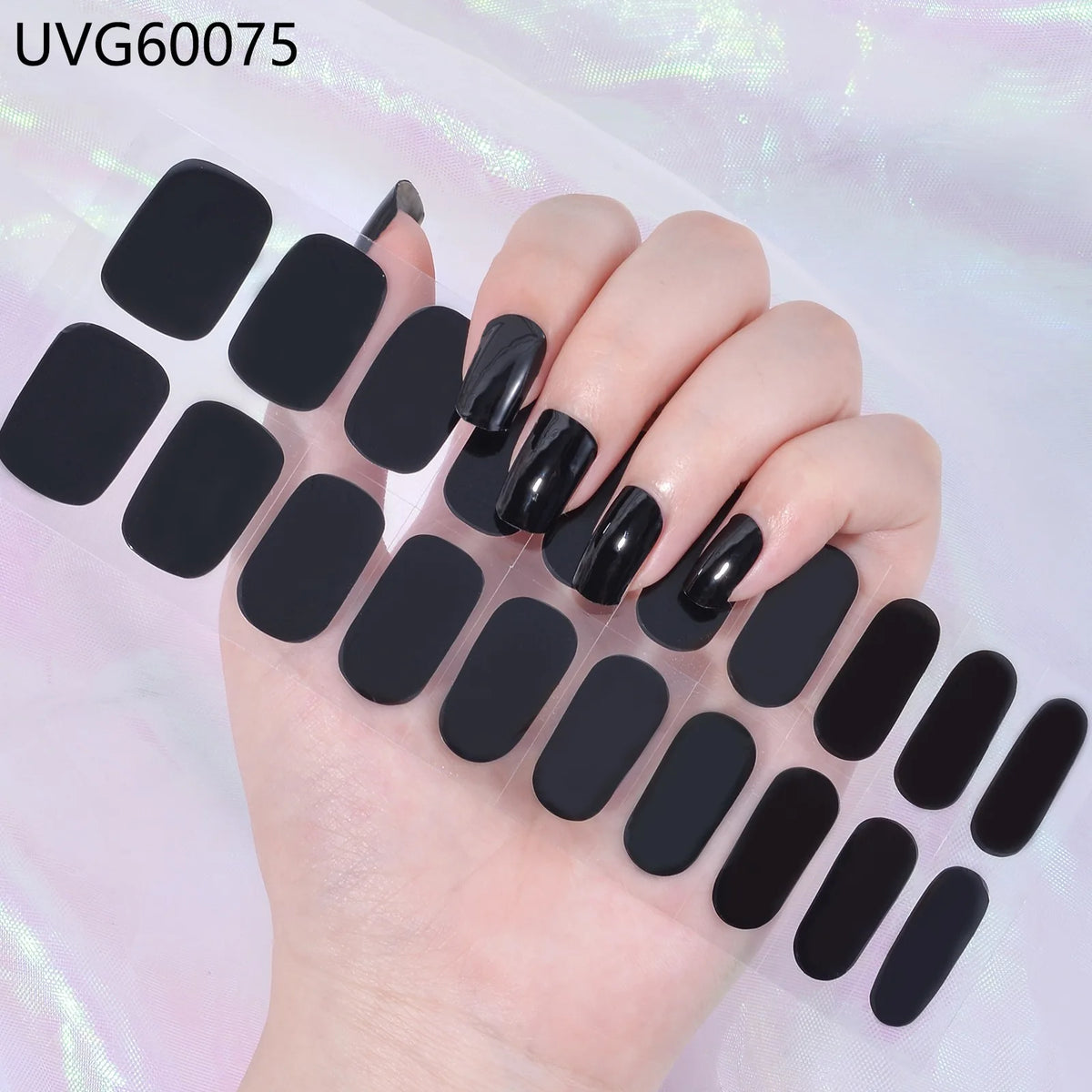 A hand displays a set of black UV gel nail stickers for full coverage decals on fingernails.