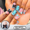 Close-up of hands displaying nude pink press-on nails with black bow and blue zebra stripes and silver charms