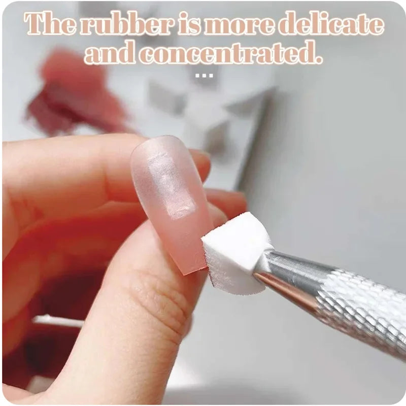 Une main utilise un tampon à ongles blanc pour appliquer du vernis gel rose dégradé sur un ongle.