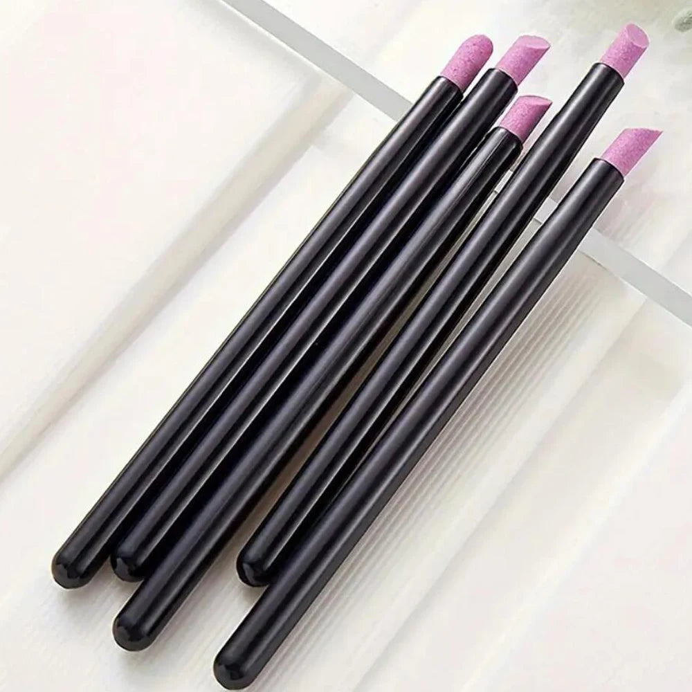 A set of black nail art liner brushes with pink tips arranged diagonally on a white surface.