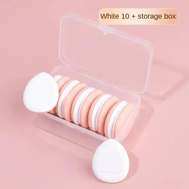 Fond de teint blanc en époussets et une boîte de rangement sont présentés sur un fond rose.