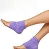 Calcetines de tacón con gel hidratante morado puestos en el pie desnudo.