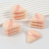 Un ensemble de puffs triangulaires roses avec des rubans de satin sur un fond blanc.