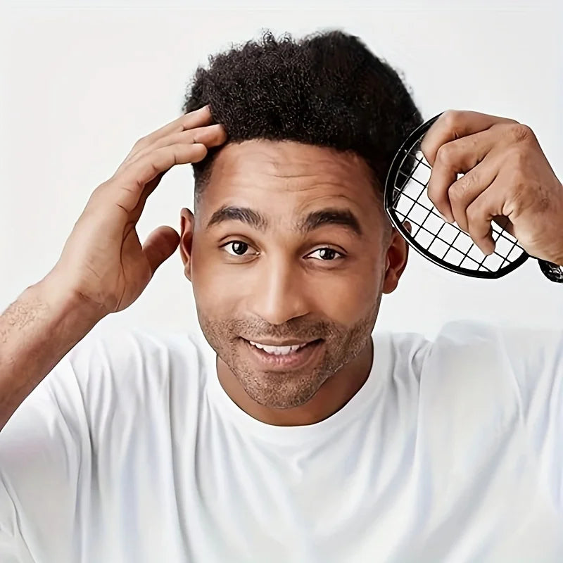 A man with a beard is holding a black hair comb near his head.