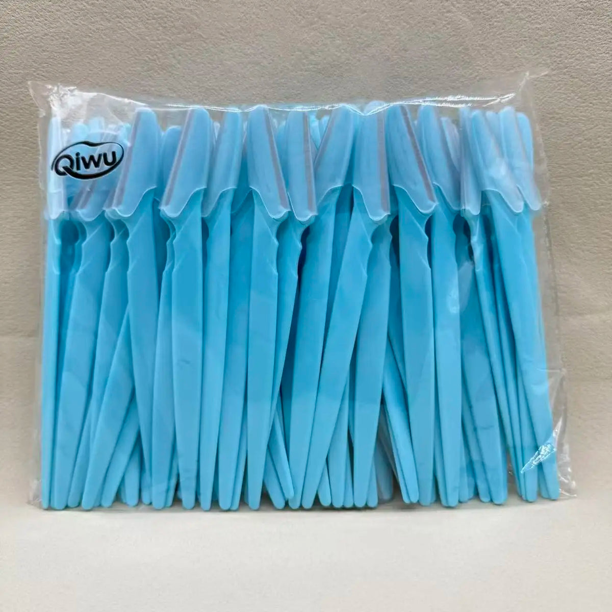 Un emballage plastique contenant un set de ciseaux à sourcils bleus clairs.