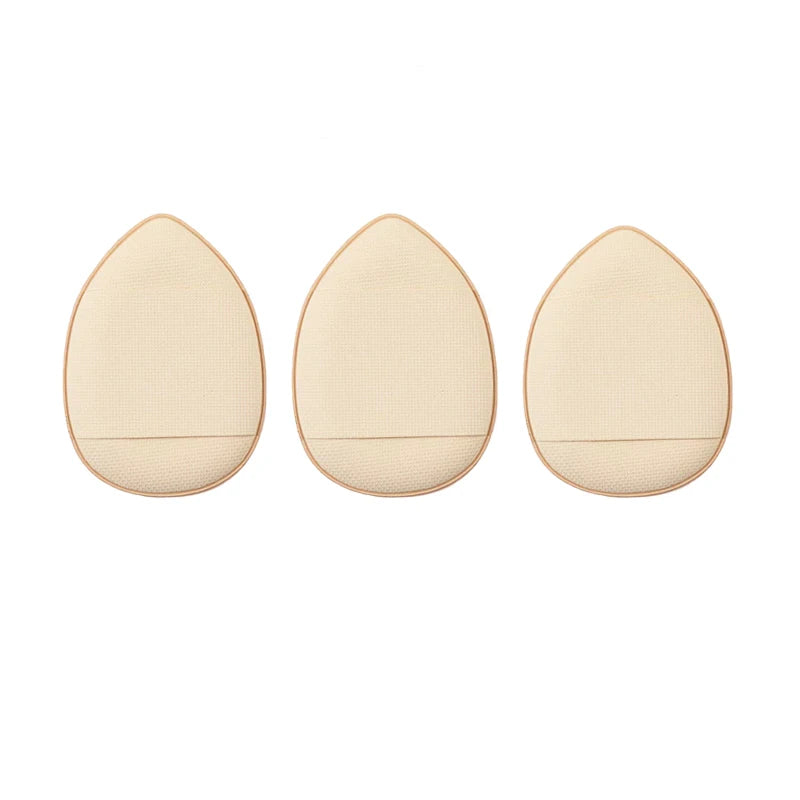 Three beige mini finger puff foundation applicator tools arranged horizontally.