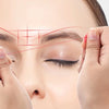 Hands are mapping an eyebrow line on a woman's face using a red thread for microblading guidance.