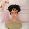 A mannequin head wearing an orange patterned afro puff turban wig with a green top and light pink background.