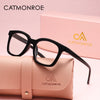 A pair of black square reading glasses resting on a pink leather case with the CatMonroe logo.
