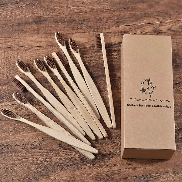 Une boîte contenant un pack de 10 brosses à dents en bambou naturel, présentée sur une surface en bois.