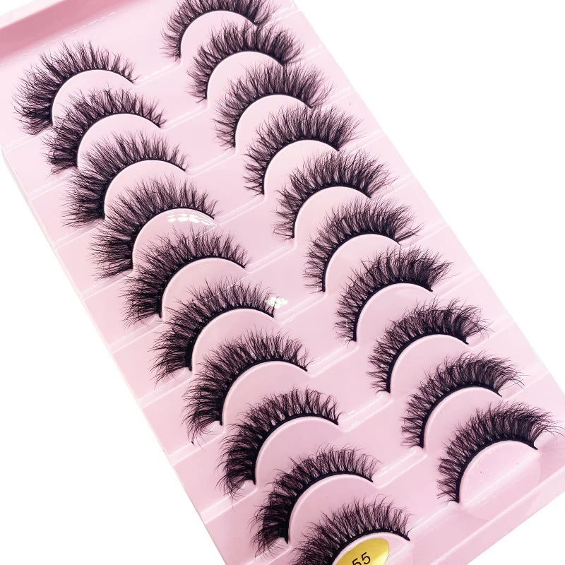 Un plateau en plastique rose contenant diverses styles de faux cils de renard noirs.