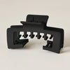 Black non-slip hat claw clips with a matte finish designed for a strong hold on baseball caps.