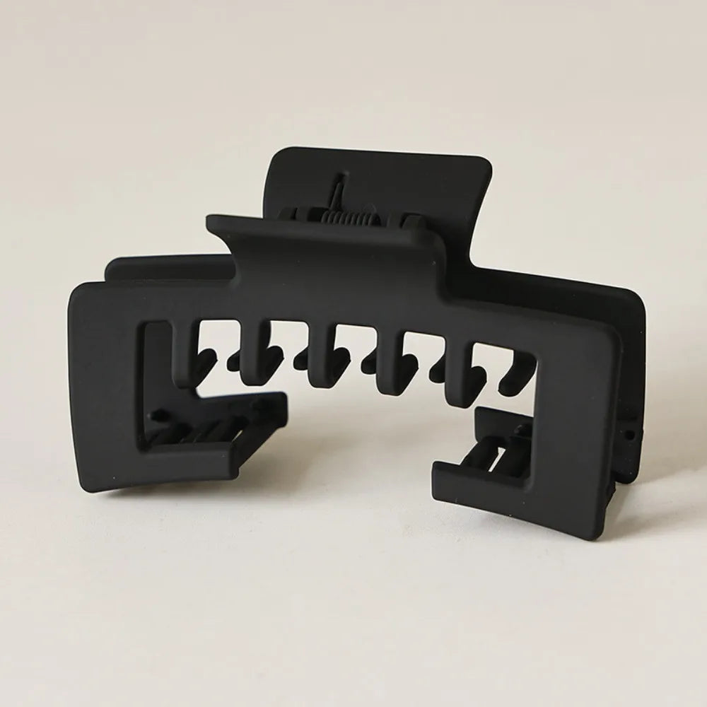 Black non-slip hat claw clips with a matte finish designed for a strong hold on baseball caps.
