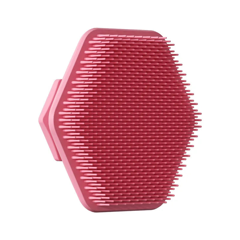 A pink silicone facial cleaning brush with numerous short bristles, shown from above.