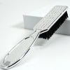 A silver professional duster brush with black bristles is shown on a white background.