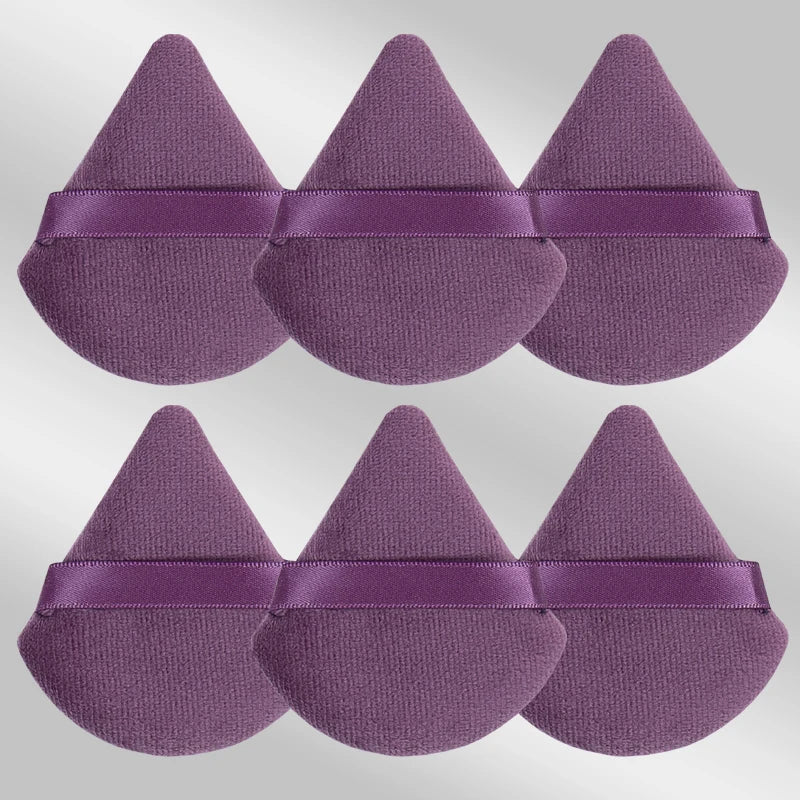Un set de six éponges de maquillage triangulaires de couleur mauve violet.