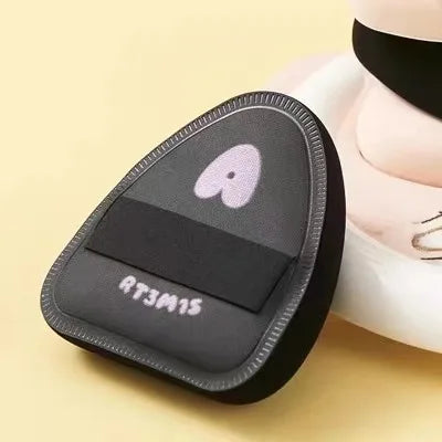 Un gros plan d'un tampon cosmétique noir avec un cœur rose et le texte RT3M15.
