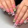 Close-up of hands displaying pink and brown press-on nails with glitter stars and animal designs.