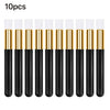 Ten black and gold eyelash extension cleaning brushes standing upright.