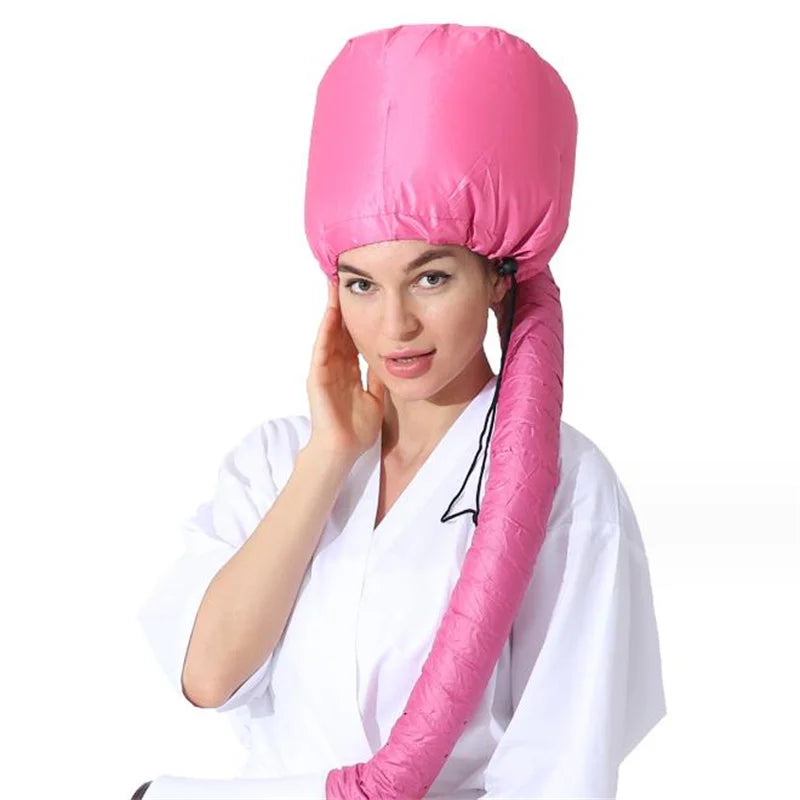 A woman wearing a bright pink adjustable hair drying cap in a salon or home setting.