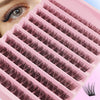 A pink lash tray with multiple rows of dark false eyelashes is shown next to an eye.