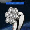 A close-up of a silver electric shaver and grooming kit with multiple rotating heads, set against a dark background with a bl