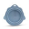 A light blue silicone makeup brush cleaner and drying stand set with a circular mesh surface.