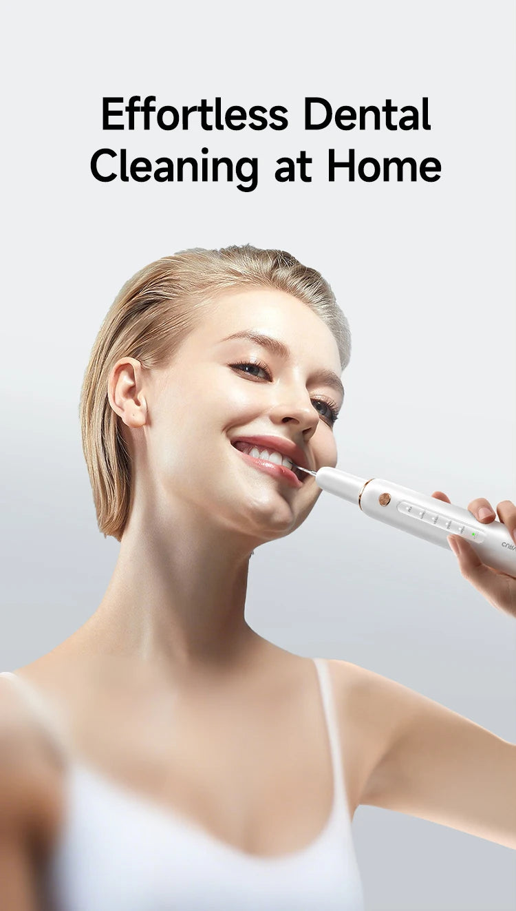 Eine Frau benutzt einen weißen Ultraschalldentalscaler zur Selbstreinigung ihrer Zähne.