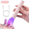 A hand holds a pink nail lamp device emitting purple light onto a fingernail for manicuring.