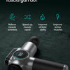 A silver muscle massage gun is shown on a dark surface, demonstrating its design.