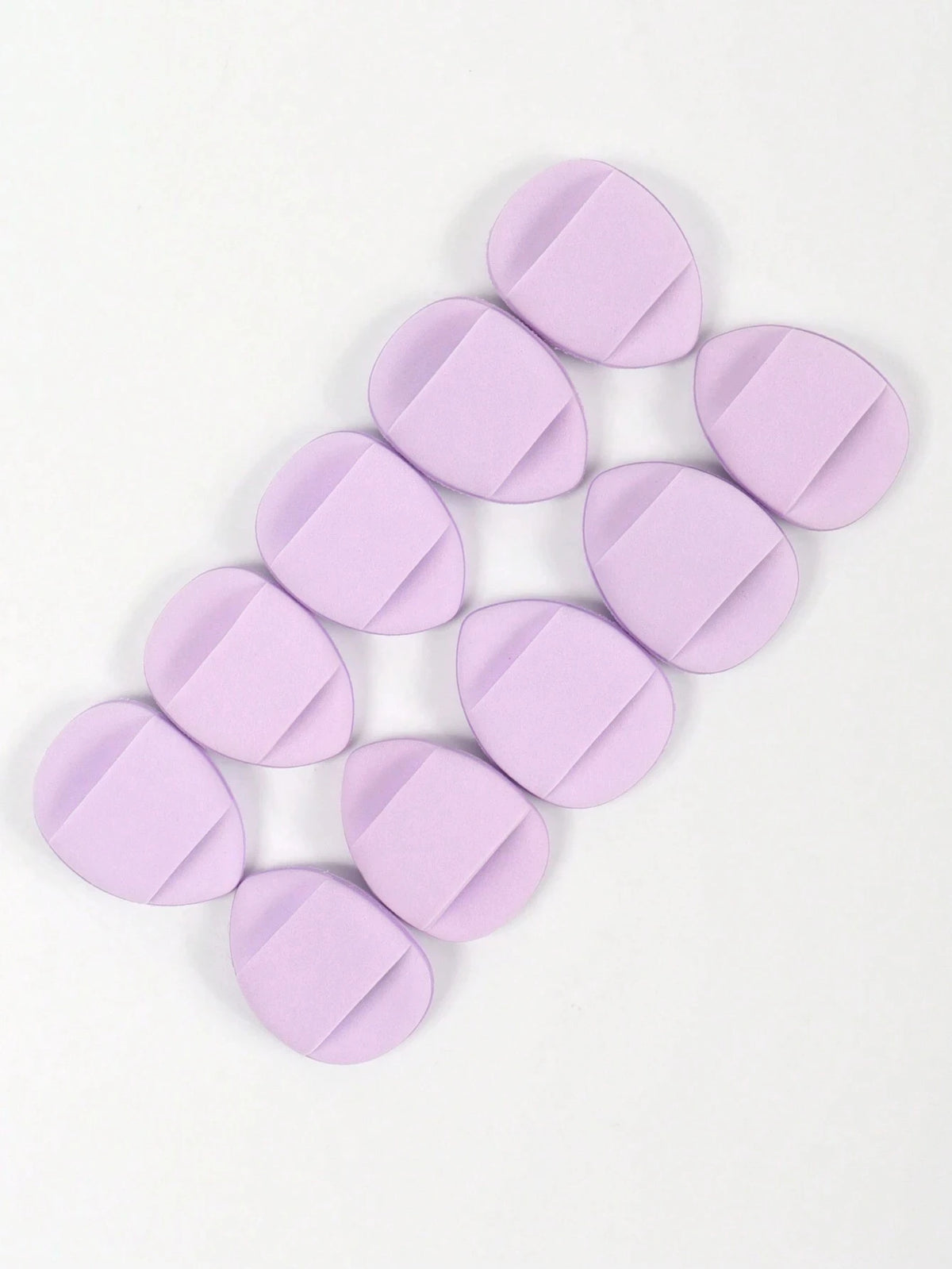 A collection of round, lavender latex-free finger puffs for makeup application.