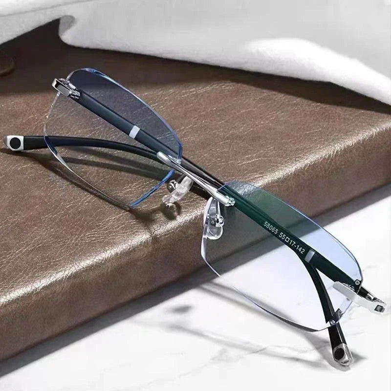 A pair of thin, dark-framed photochromic reading glasses resting on a brown leather surface.