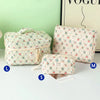 Three quilted cotton makeup bags in various sizes L M S displayed on a white surface.