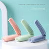 Three colored folding combs displayed on a white stand, showing the dual-purpose design.
