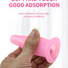 A hand is holding a pink silicone facial cupping tool for massage and skin rejuvenation.