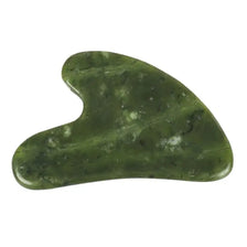 A smooth, oval-shaped piece of green jade used as a gua sha tool for facial massage.