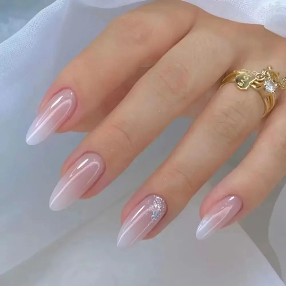 A hand displaying press-on false nails with a French wavy design and gold jewelry.
