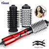 A set of three black and white hot air brushes for hair styling including a handheld straightener
