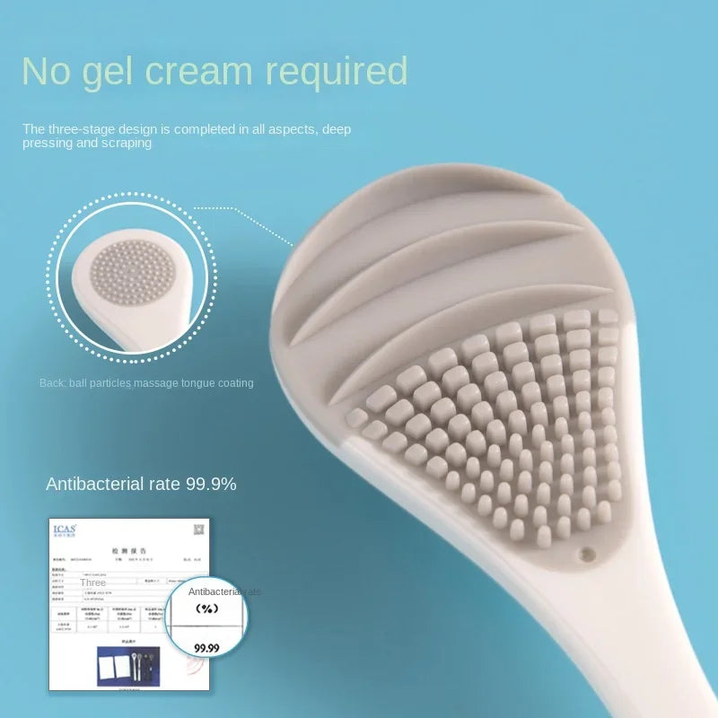 A close-up view of a white reusable tongue cleaner brush with silicone bristles, demonstrating its three-stage design.