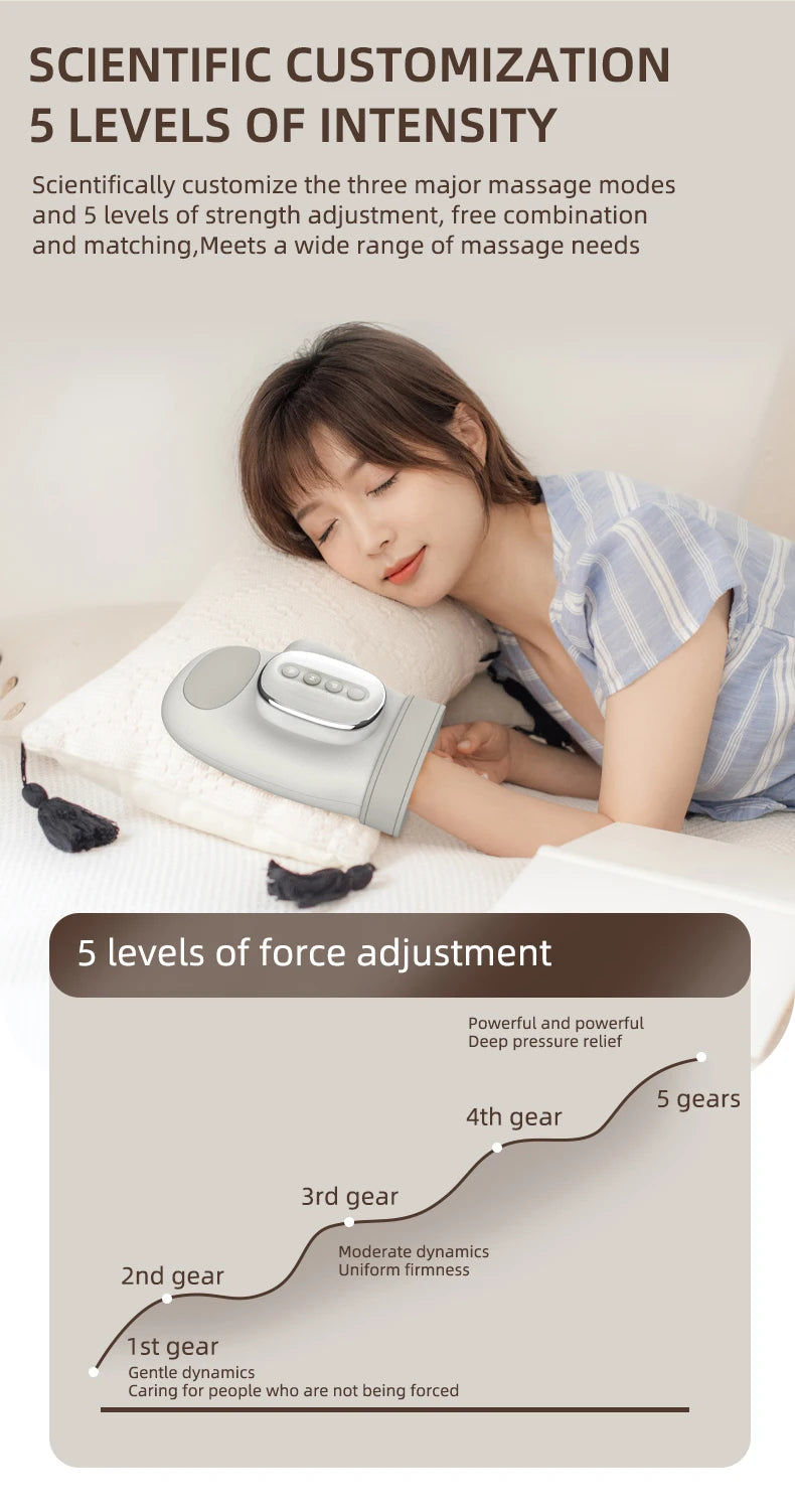 A woman is using a silver electric hand massager for massage therapy on her shoulder.