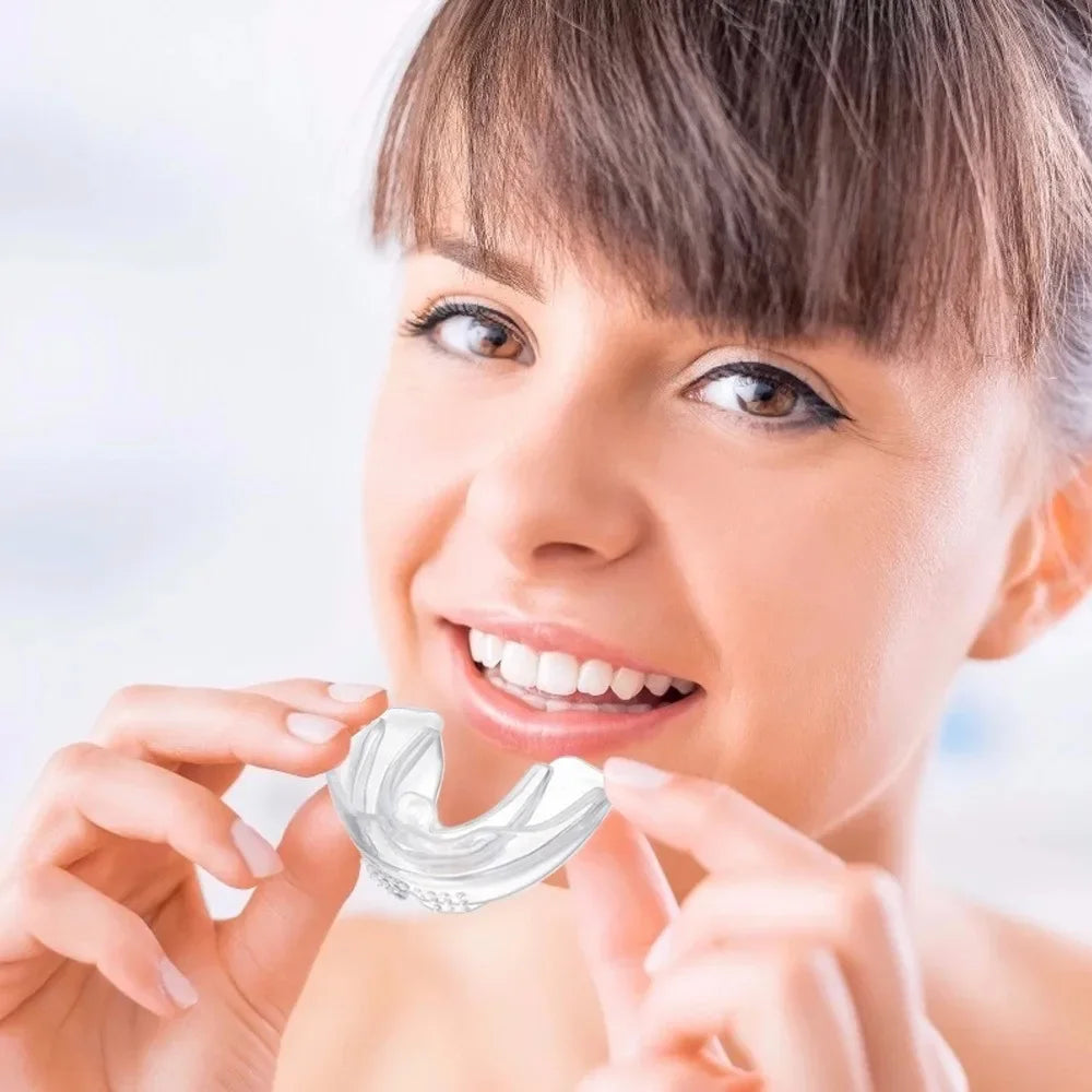 A woman is using a clear silicone dental alignment trainer to show her teeth.