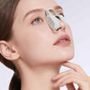 A woman is using a white microcurrent nose lifter and sculpting tool on her face.