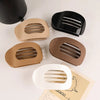 A collection of oval flat hair clips in beige, brown, and white tones arranged on a white surface.