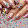 Close-up of manicured fingers displaying various floral and butterfly nail stickers for DIY decoration
