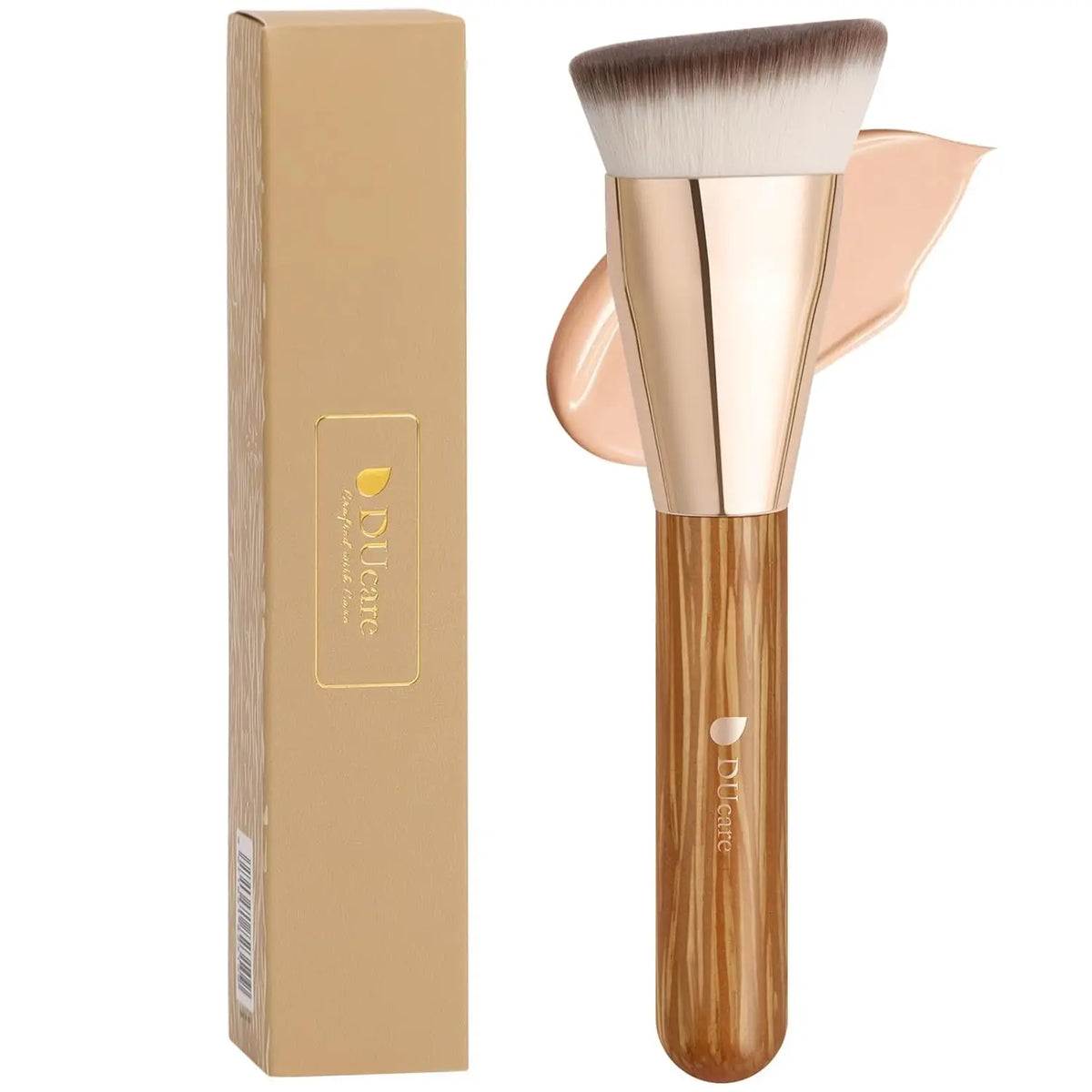 A wooden makeup foundation brush with a pink handle and tapered bristles shown next to its packaging box.